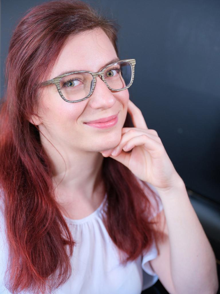 Portrait einer jungen Frau mit roten Haaren und Brille