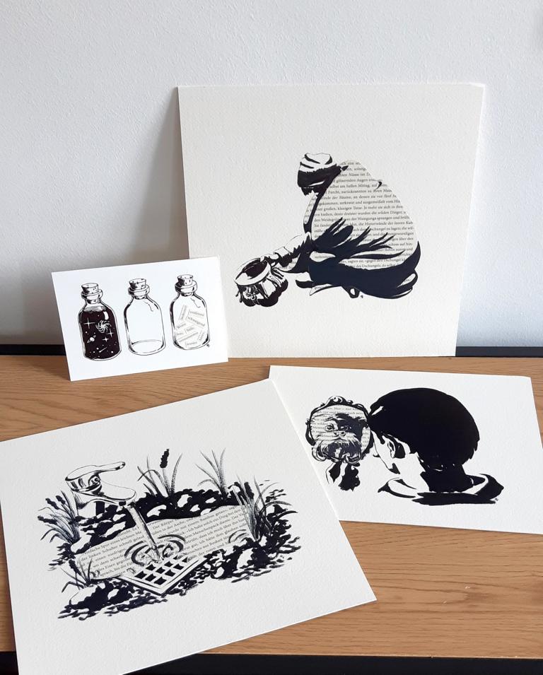 Vier Tintenzeichnungen mit Elementen aus Buchseiten sind auf einem Tisch präsentiert